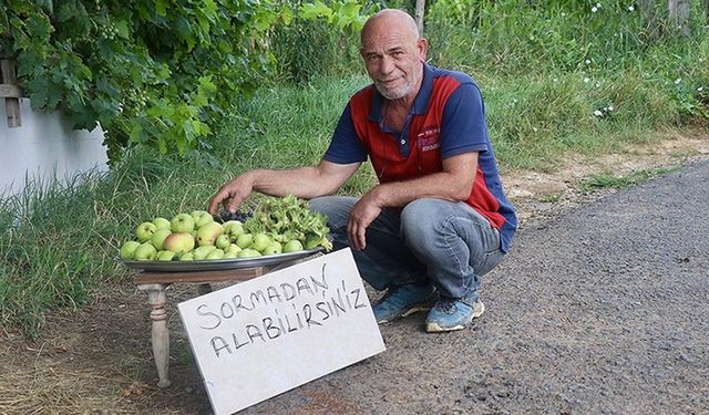 Bahçesinde yetiştirdiği ürünleri yoldan geçenlerle paylaşıyor